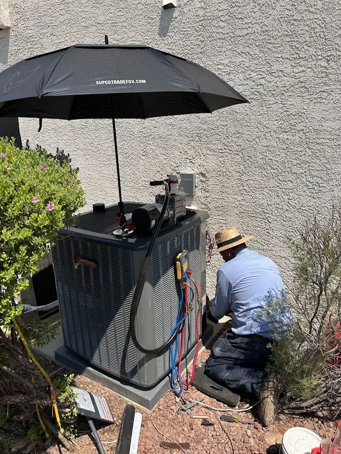 HVAC technician performing outdoor AC maintenance in Glasgow